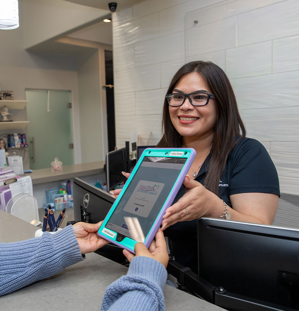 staff member helping patient at the front desk of the dental center