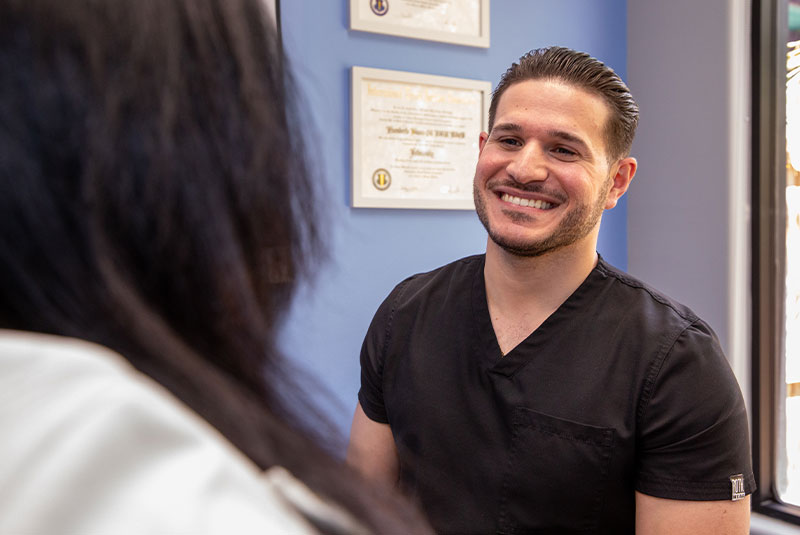 doctor smiling brightly while going over dental procedure information
